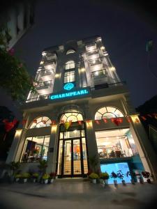 河内Charmpearl Hotel & Suites的晚上有招牌的建筑物