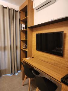 una habitación con un escritorio y un televisor en la pared en Apollo Studio, en São Paulo