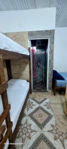 a room with two bunk beds and a tile floor at Hospedaje Espindoliky in Bella Vista