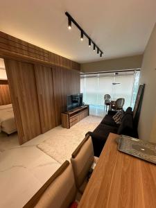 a living room with a couch and a television at Loft Modern and Convenient - Garage Included in Sao Paulo
