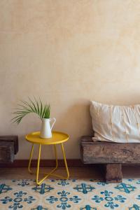 a table with a vase on it next to a bench at Mero Mero Hotel in El Cuyo +59 photos