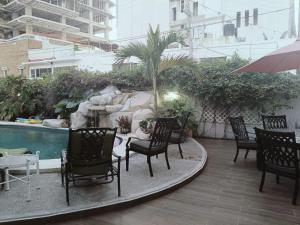 a group of chairs sitting on a patio next to a pool at Departamentos con Alberca in Mazatlán