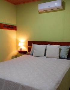 a bedroom with a bed with white pillows at Arenal More Apartamento in San Ramón