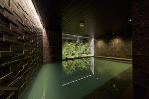 a swimming pool in a building with a plant at Hotel Global View Koriyama in Koriyama