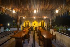 a restaurant with wooden tables and chairs in a room at Simpang Inn Hostel in Nusa Penida