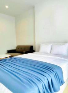 Un dormitorio con una cama con una manta azul encima. en อพาร์ตเม้นต์แสนสงบ, en Thonhuri