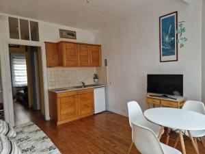 kuchnia ze stołem, zlewem, stołem i krzesłami w obiekcie Holiday flat with sea and garden view, just 400m from the beach in Port-Blanc w mieście Penvénan +11 zdjęć