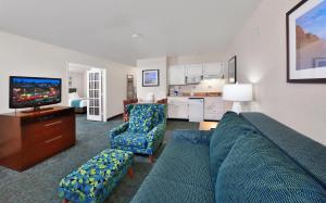 a living room with a couch and chairs and a television at Old Town Inn in San Diego