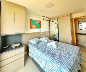 a bedroom with a bed with a dresser and a cabinet at Lindo Apartamento dentro do Shopping in Águas Claras +15 photos