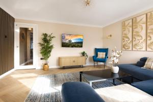 a living room with a blue couch and a blue chair at Spacious 3 Bed Home in Glasgow City With Free Parking in Glasgow