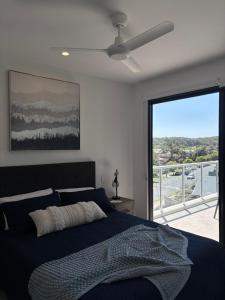 a bedroom with a bed and a ceiling fan at The Arthur Apartments in Coffs Harbour