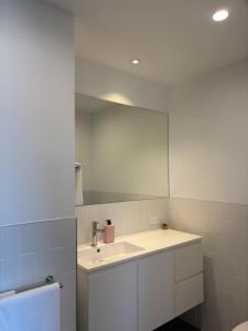 a bathroom with a sink and a mirror at The Arthur Apartments in Coffs Harbour +30 photos