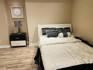 a bedroom with a bed with black and white pillows at Nice and Cozy 2 Bed Bsmt Apt in Pickering