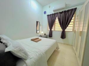 a bedroom with a white bed and a window at Eira Homestay Lost World Of Tambun M uslim only in Ipoh +22 photos