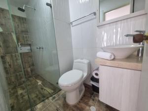 a bathroom with a toilet and a sink and a shower at Apartahotel Rubí San Gil in San Gil +10 photos