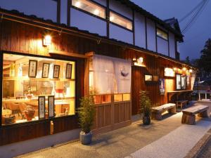 宫津市籠屋mizunotoオーベルジュ的大楼前方的商店,前面有长凳