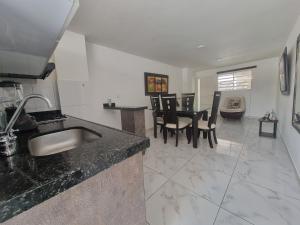 a kitchen with a sink and a table with chairs at Apartahotel Rubí San Gil in San Gil