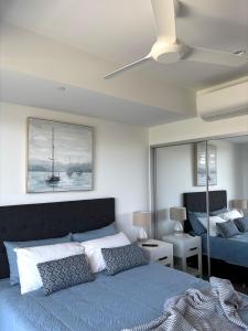 a bedroom with a blue bed and a mirror at The Arthur Apartments in Coffs Harbour