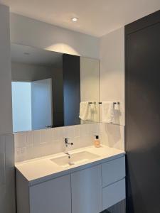 a bathroom with a sink and a mirror at The Arthur Apartments in Coffs Harbour