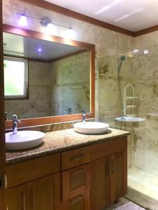 a bathroom with two sinks and a large mirror at Hispañola Beach Beautiful condo with private beach two bedrooms in Sosúa