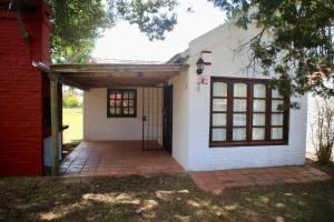 a house with a garage and a brick driveway at Cabañas Country in La Paloma