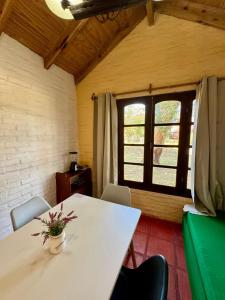 a table and chairs in a room with a window at Cabañas Country in La Paloma