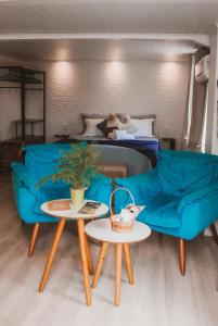 a living room with a blue couch and two tables at Pousada Bella Vista - no coração do Vale dos Vinhedos in Bento Gonçalves