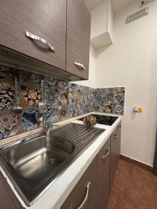 une cuisine avec un évier et du carrelage au mur dans l'établissement Vat' Coke House, à Naples