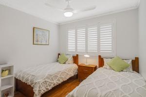 Un dormitorio con dos camas y una ventana. en Kirra Beachside, en Gold Coast