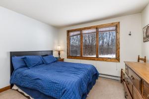 a bedroom with a blue bed and a window at 4-Bedroom Townhouse in Beautiful Galena in Galena +28 photos