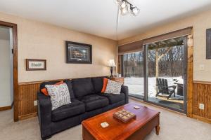 a living room with a black couch and a table at 4-Bedroom Townhouse in Beautiful Galena in Galena