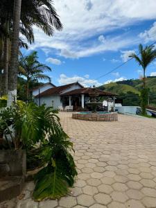 a resort with palm trees and a building at Chalé das Hortênsias em São Lourenço a 2 km do Parque das Águas in São Lourenço