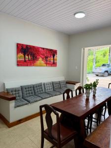 a living room with a couch and a table at Chalé das Hortênsias em São Lourenço a 2 km do Parque das Águas in São Lourenço