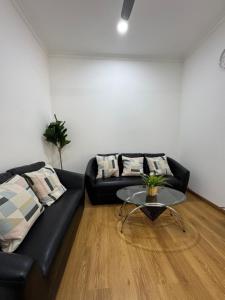 a living room with a black couch and a table at Sea View in Meedhoo