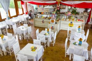 a restaurant with white tables and white chairs at Pousada Nascer do Sol in Penha