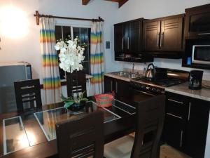 a kitchen with a glass table and a colorful curtain at Cabaña con Bañera y Chimeneas en San José del Pacífico in El Pacífico