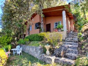 a house with a staircase leading to the front yard at Cabaña con Bañera y Chimeneas en San José del Pacífico in El Pacífico