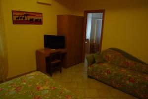 a living room with a couch and a tv at Pensione Campese in Formia
