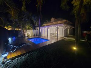 a backyard with a swimming pool and a gazebo at night at Villa SAINT BARTHELEMY in Saint-François