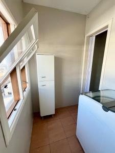 a room with a refrigerator and a window at Cobertura duplex 3 quartos, centro, terraço e churrasqueira, ideal para família, acesso por escadas in Torres