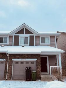 a house with a garage and two trash cans at Entire Beautiful and Cozy Home in Edmonton