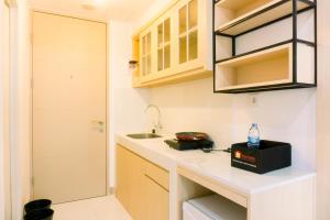 a small kitchen with a sink and a counter at New and Nice Designed Studio at Tokyo Riverside PIK 2 Apartment By Travelio in Rawalembang