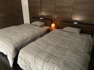 two beds sitting next to each other in a bedroom at ステイインアット今福 in Sasebo +25 photos