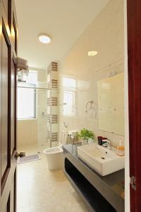 a bathroom with a sink and a toilet and a mirror at The Hill An Sơn DIC in Xuan An