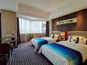 a hotel room with two beds and a desk at Kunming Haitian Hotel in Kunming +82 photos