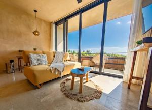 a living room with a couch and a table at Luxury Romantic Getaway - 1 Bedroom - Steps from the Beach - Bahia Tankah Tulum in Tulum