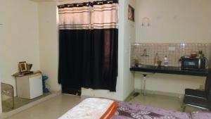 a room with a bed and a black shower curtain at Vrinda stays in Chhatikara