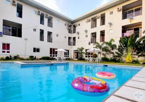帕古普Three M's Hotel and Restaurant的一座游泳池,在一座建筑前设有充气木筏