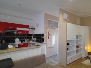 a kitchen with red and white cabinets in a room at Edina Apartman in Sátoraljaújhely