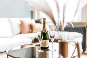 a bottle of champagne and two glasses on a table at Haya Historic - Rosé in The Hague
